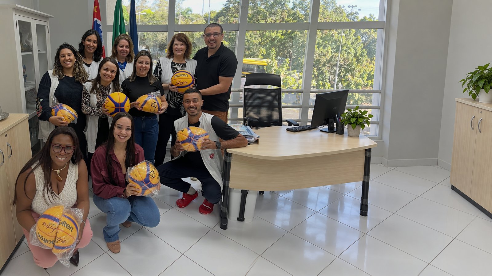 NBB e a psicóloga Mila doam bolas de basquete para os atendidos da APAE Barueri
